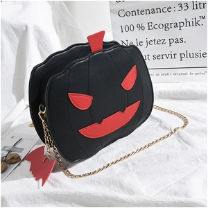 Detail of black leather pumpkin bag with red smiley face and golden chain strap