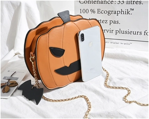 Detail of orange pumpkin bag with black chain strap and bat charm for Halloween