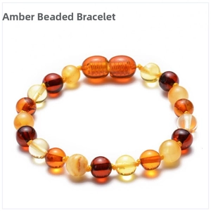Macro detail of multi-color Baltic amber bead bracelet showing polished texture on white background