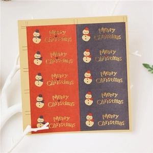 Close-up of vintage kraft paper Christmas stickers with gold foil Merry Christmas text