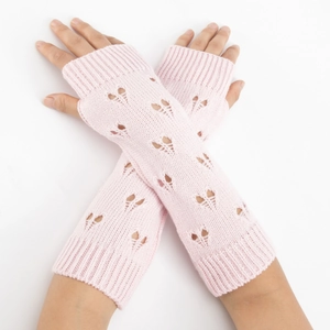 Detail of pink knitted arm warmers with heart cutouts and ribbed cuffs for women