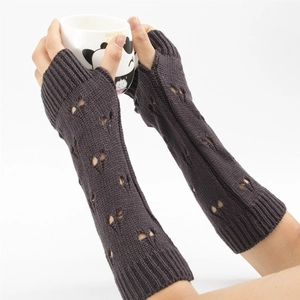 Close-up of dark grey knitted arm warmers featuring a stylish hollow heart pattern detail