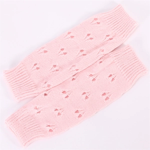 Detailed knit pattern of pink fingerless arm warmers with a hollow heart-shaped design