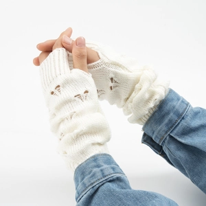 Detailed knit pattern on long white fingerless arm warmers with heart-shaped embroidery