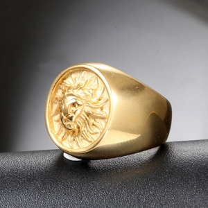 Macro side view of gold lion head relief ring on black leather textured display