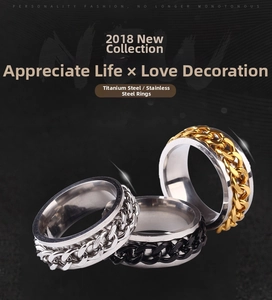 Detailed view of silver, black and gold spinner rings with stainless steel chain texture