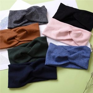 Close-up of assorted ribbed knit cross headbands in seven elegant colors on a stylish background
