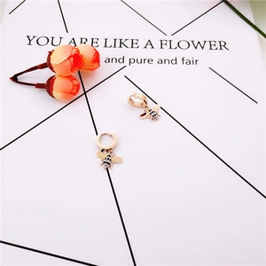 Gros plan de boucles d'oreilles abeille en or rose avec cristaux sur carte décorée