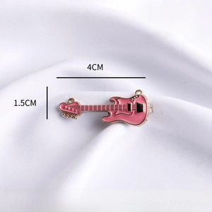 Detailed macro view of a pink enamel mini guitar brooch with 4cm length measurements