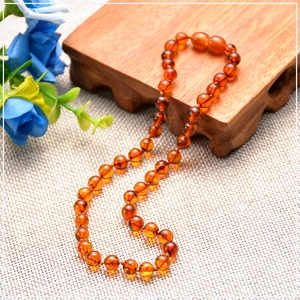 Detailed macro view of natural Baltic amber beads with fine texture on textured fabric