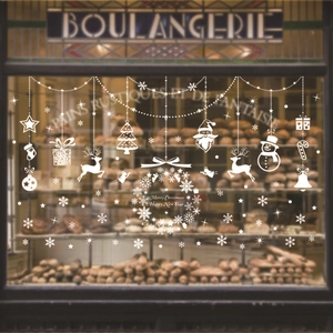 White Christmas window decals with Santa and reindeer on a bakery glass storefront
