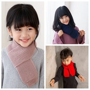 Three children wearing knitted winter scarves in pink, navy blue, and red colors