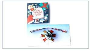 Detailed view of 3D pop-up Christmas card featuring a colorful festive inner paper carving
