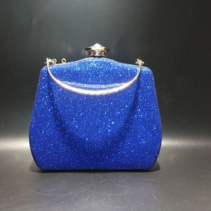 Macro shot of shimmering blue evening bag with gold metal frame and crystal clasp