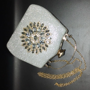Detailed macro view of the silver evening clutch featuring a crystal sunflower ornament