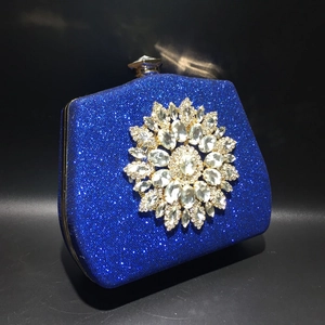 Close-up of blue glitter evening clutch with large crystal sunflower and gold clasp