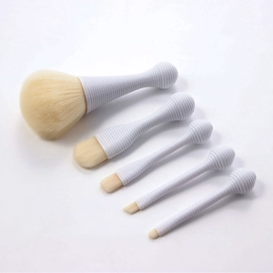 Detail of 5-piece portable makeup brush set with white threaded handles and soft cream bristles