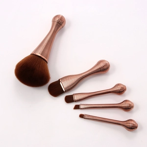 Detail showing 5 lollipop makeup brushes with rose gold threaded handles and soft brown bristles