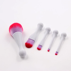 Detailed macro view of 5 makeup brushes with white spiral handles and purple gradient bristles