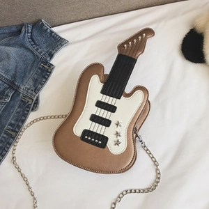 Detailed top view of a brown and white guitar-shaped crossbody bag with gold chain strap