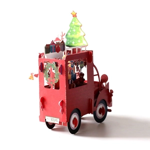 Creative 3D pop-up Christmas card featuring a red gift truck with a decorated tree