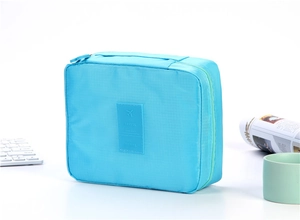 Detail of light blue travel toiletry bag with woven texture and top handle