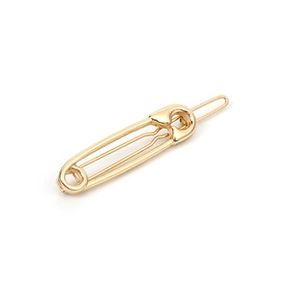 Detailed view of the gold safety pin shaped hair clip with polished metallic finish