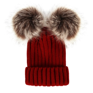 Detailed knit texture of red baby winter hat with double brown faux fur pom poms