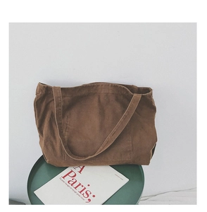 Close-up of minimalist brown canvas tote bag with shoulder strap and clean stitching