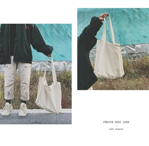 Detail of a large off-white canvas tote bag in a minimalist French chic aesthetic