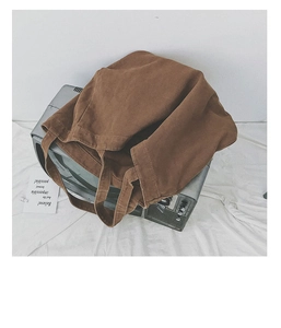 Close-up of brown canvas tote bag texture placed on a vintage TV set with white backdrop