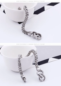 Macro detail of men's stainless steel wheat chain bracelet with interlocking clasp