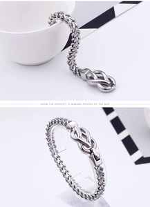 Close-up of silver dragon bone chain bracelet with detailed Celtic knot clasp design