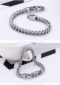 Macro detail of men's stainless steel franco chain bracelet with vintage engraved clasp