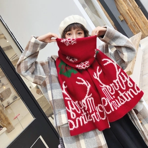 Winter red knitted Christmas scarf with snowflake patterns and Merry Christmas text