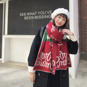 Close-up of red Christmas knit scarf with white snowflake patterns and Merry Christmas text