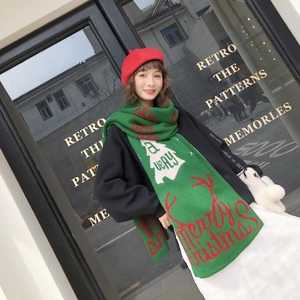 Detail of green knit scarf with red reindeer pattern and Merry Christmas text