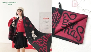 Close-up of black knitted Christmas scarf with festive white snowflake patterns