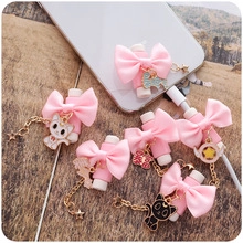 Pink silk bow with metal anime charms for phone cable decoration and accessory protection