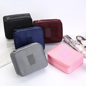 Multi-colored travel toiletry bags in black, blue, burgundy, grey, and pink nylon
