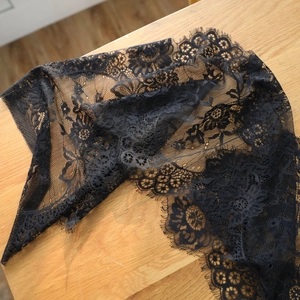 European black eyelash lace table runner with floral patterns on a wooden table surface