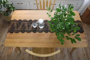 High-angle view of black eyelash lace table runner on a wooden dining table decor