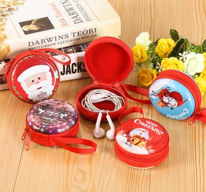 Detailed close-up of festive Christmas tin coin purses with zippers on a wooden surface