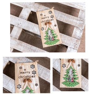 Detail of wooden Merry Christmas door sign with pine cones and green tree cutout
