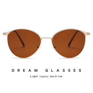 Detailed front view of retro gold metal frame sunglasses with dark amber lenses