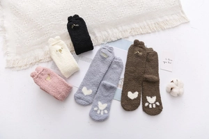Flat lay of five pairs of soft coral fleece socks with cat ears and heart patterns