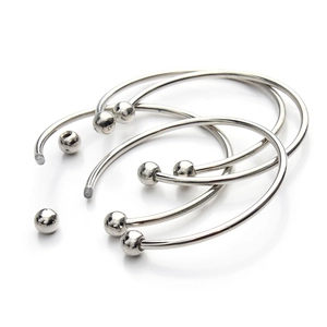 Close-up of silver stainless steel C-shape bracelet with removable threaded ball ends