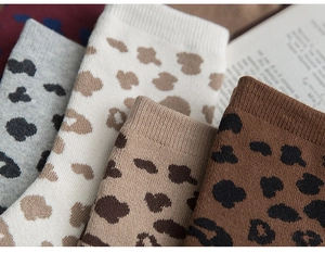 Detailed knit texture of four retro leopard print cotton socks with ribbed cuffs