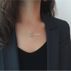 Detail of S925 sterling silver circle necklace with milgrain edge on black blazer