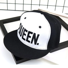 Detail view of monochrome hip hop cap featuring white front with black QUEEN. embroidery